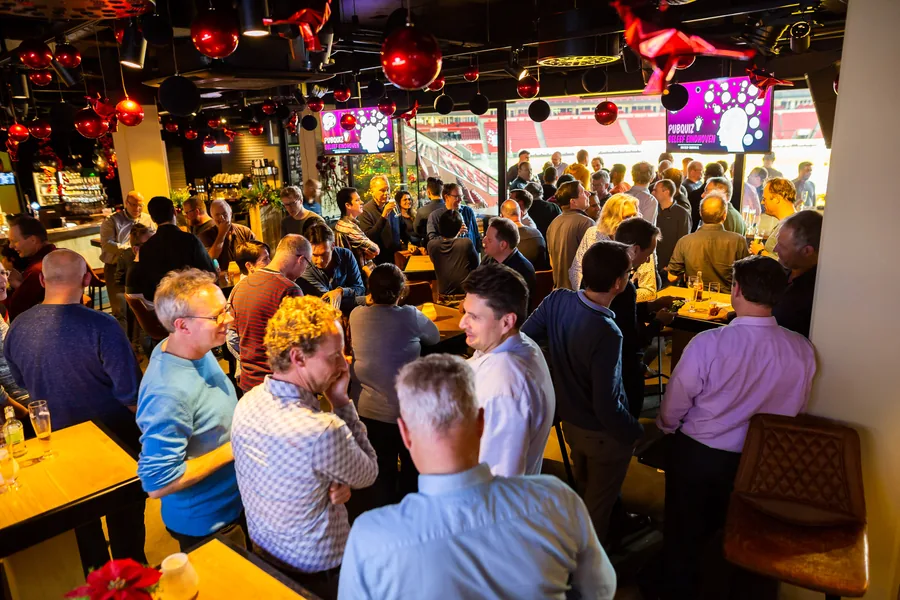 Groep mensen tijdens een gezellige kerstquizavond in Eindhoven